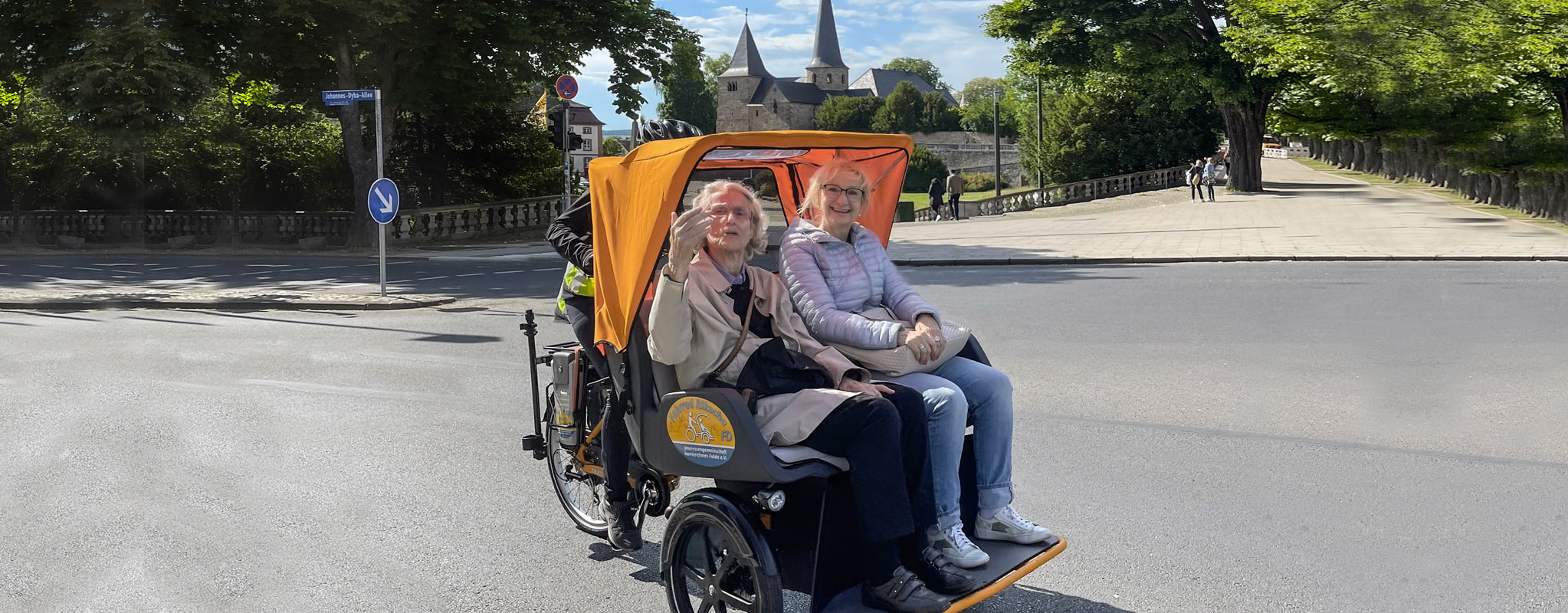 Ein Paar fährt mit einer Fahrrad-Rikscha durch die Stadt.